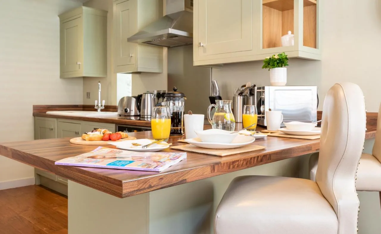 A fully equipped kitchen with a wooden table at The Lawrance Luxury Aparthotel, York