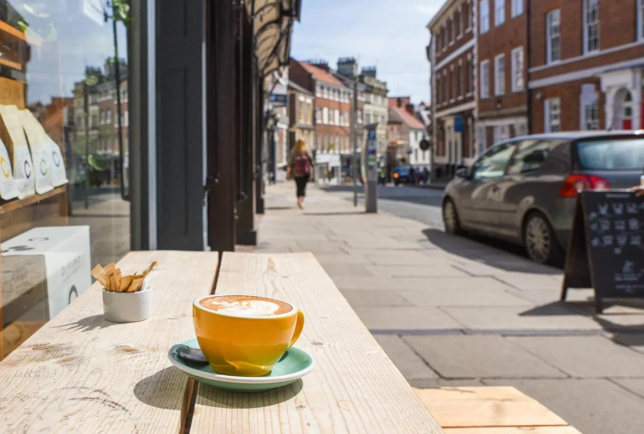 A cup of coffee on a wooden table at The Lawrance Luxury Aparthotel, York