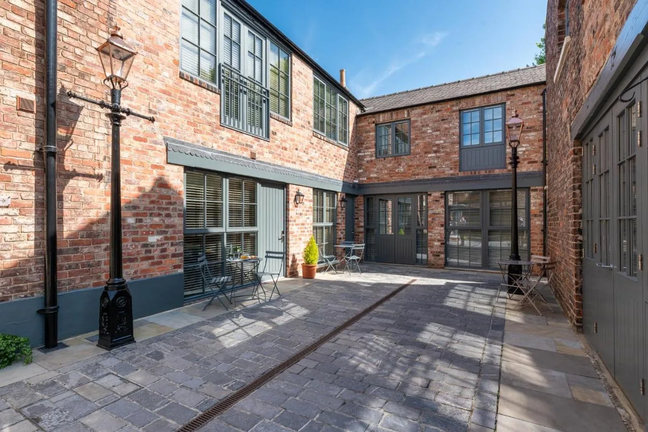 A brick courtyard with tables and chairs at The Lawrance Luxury Aparthotel, York